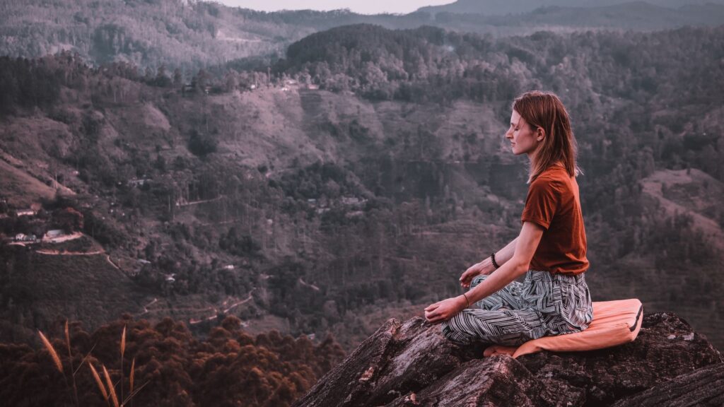 Woman meditating on a mountain