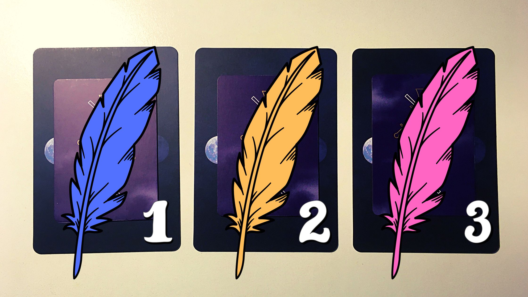 Three tarot and oracle pick a card piles with feathers on top of them