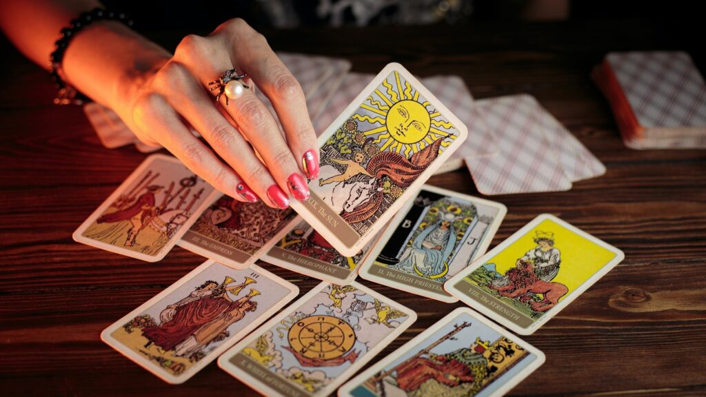 A woman selecting a tarot card from a spread