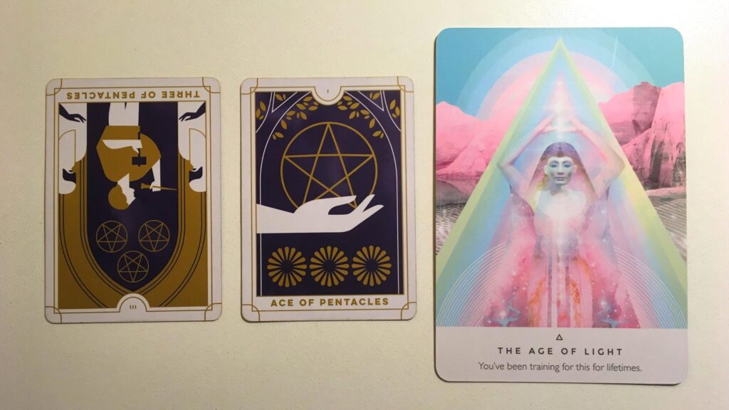 Three of Pentacles, Reversed and the Ace of Pentacles from the Everyday Tarot deck; the Age of Light from the Work Your Light oracle deck