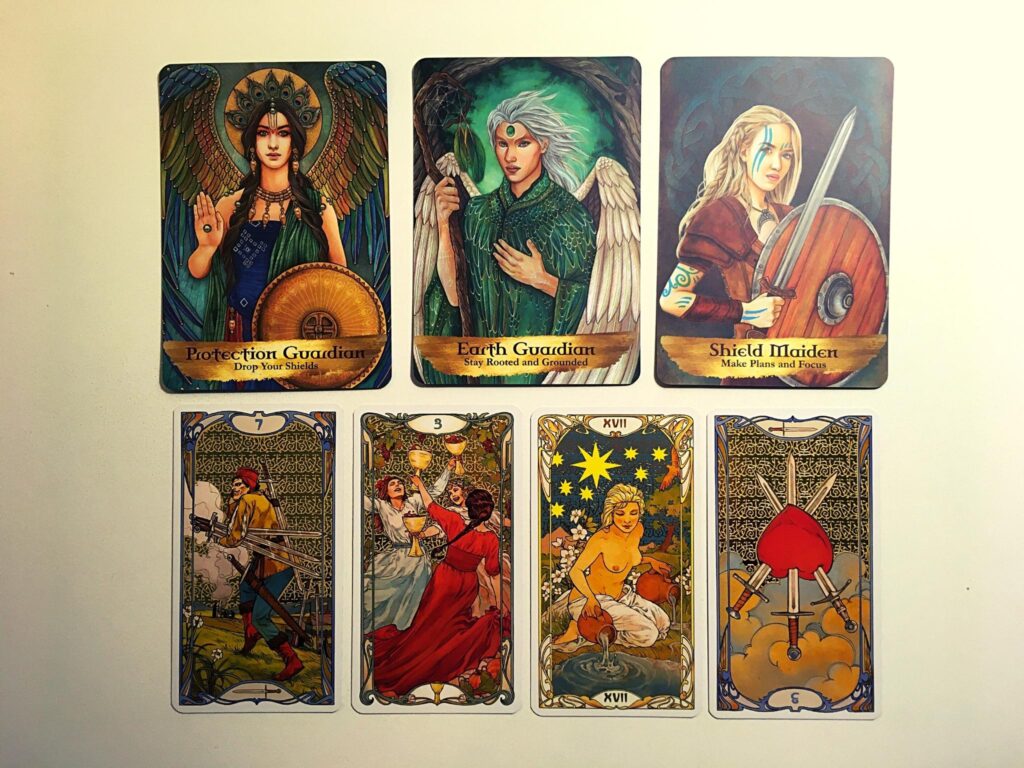 Protection Guardian, Earth Guardian, and Shield Maiden from the Angels and Ancestors oracle deck; the Seven of Swords, Three of Cups, the Star, and the Three of Swords Reversed from the Golden Art Nouveau Tarot Deck