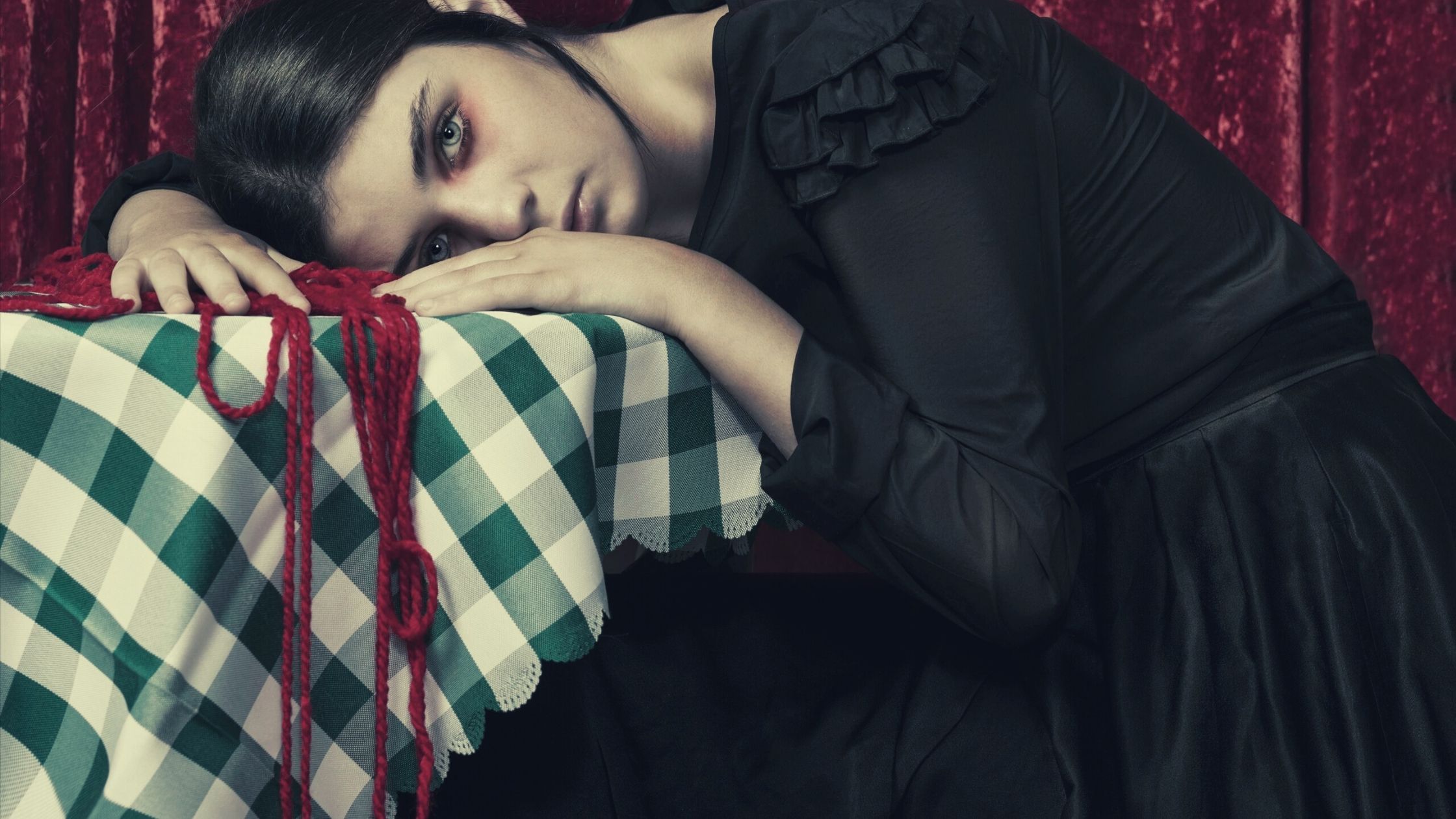 A tired woman leaning on a table dramatically