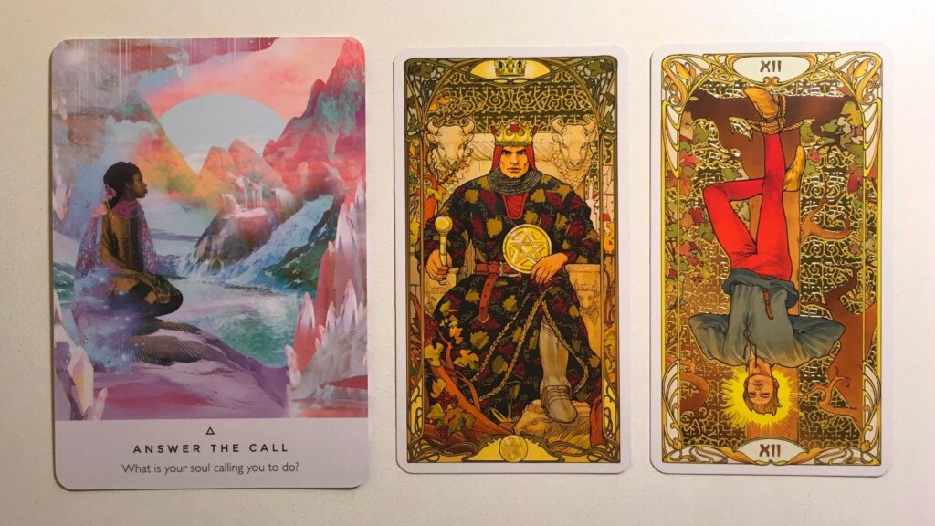 Answer the Call from the Work Your Light Oracle deck; the King of Pentacles and The Hanged Man from the Golden Art Nouveau Tarot deck