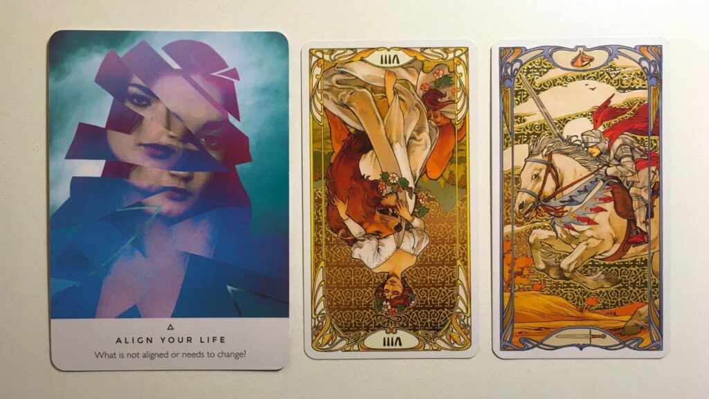 Align Your Life from the Work Your Life Oracle deck; the Strength, Reversed and Knight of Swords cards from the Golden Art Nouveau Tarot deck