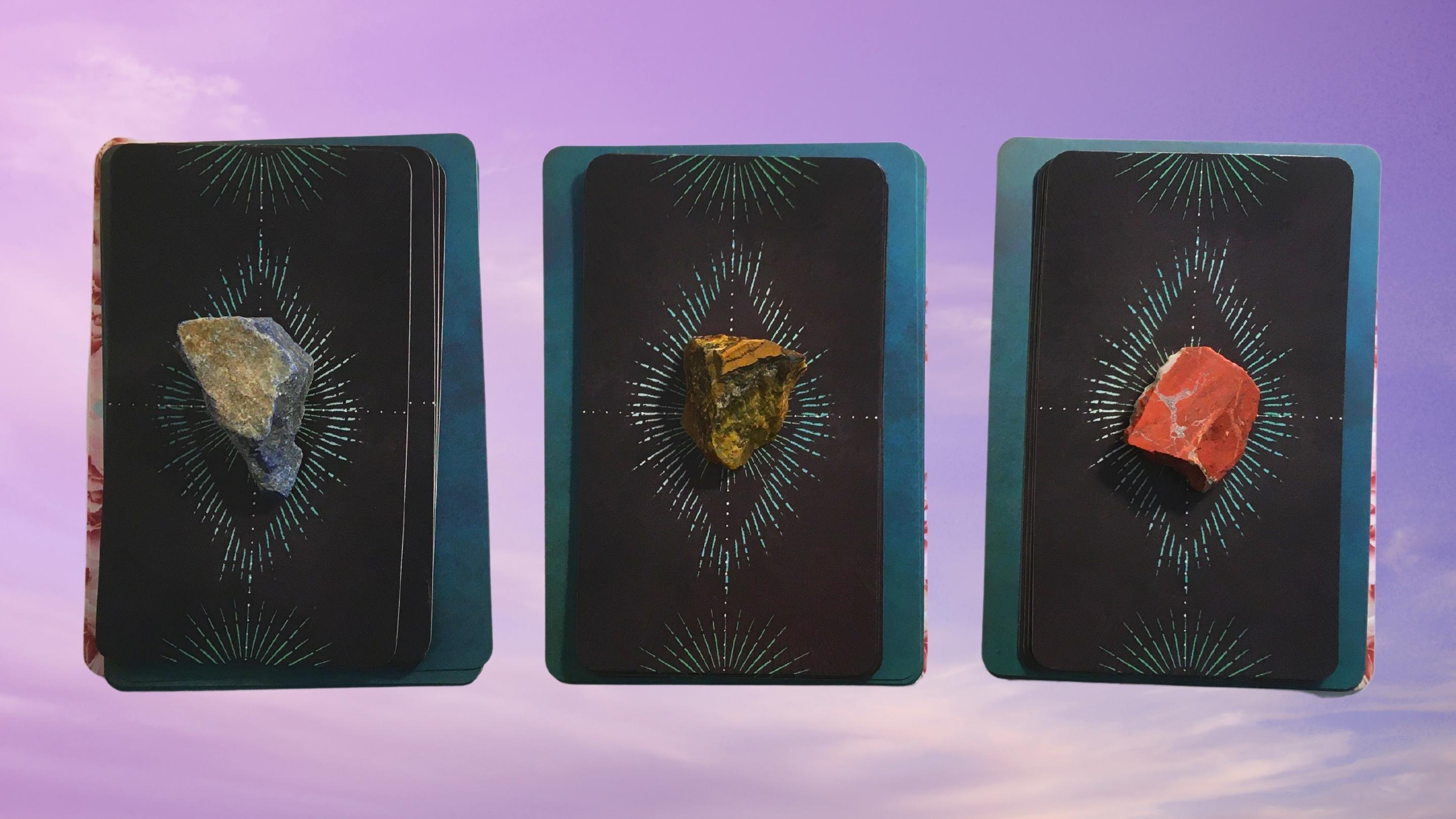 Three tarot and oracle pick a card piles with crystals on them