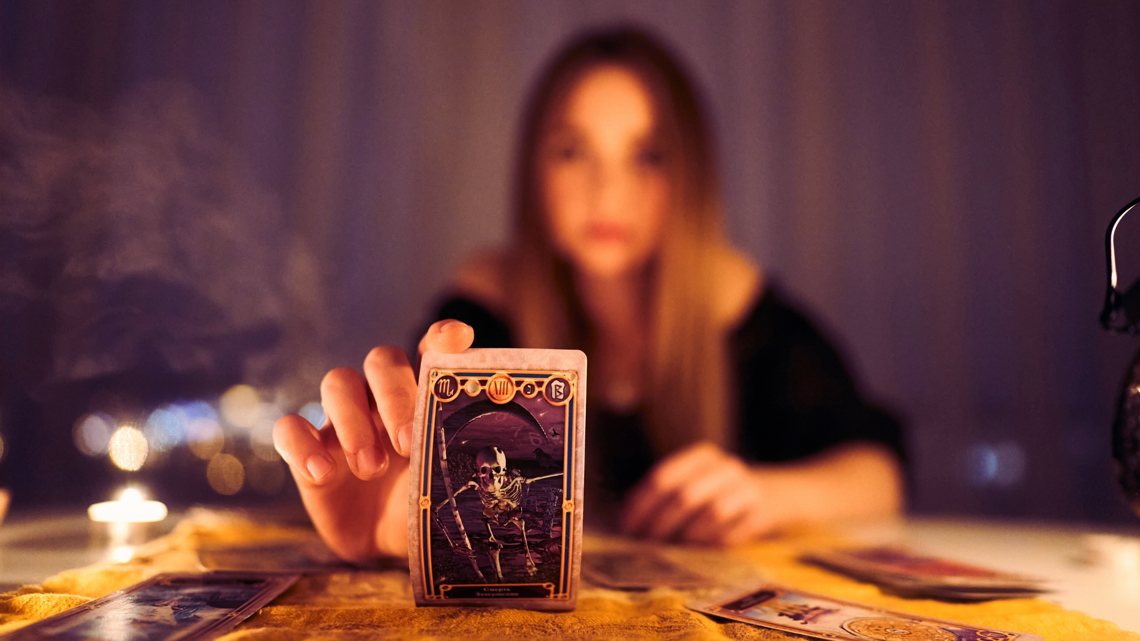 A woman reading tarot cards with the death card showing