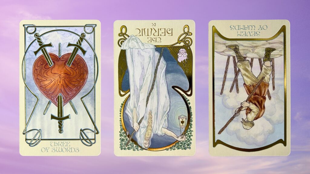 Cards from the Ethereal Visions Illuminated Tarot deck: Three of Swords, The Hermit, and Seven of Wands