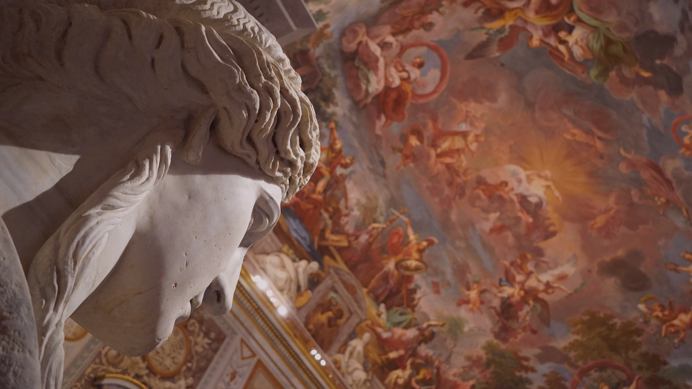 A greek statue being a painted ceiling of gods